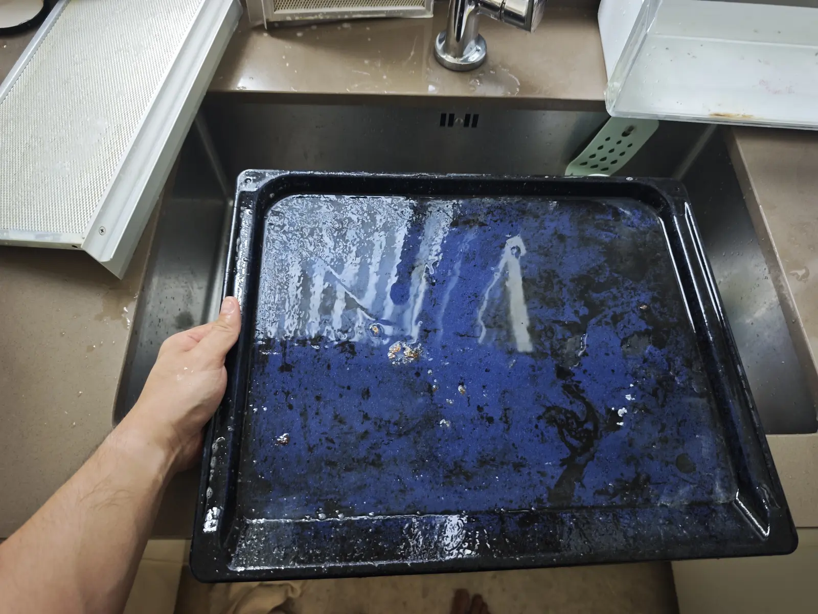 Oven tray being cleaned