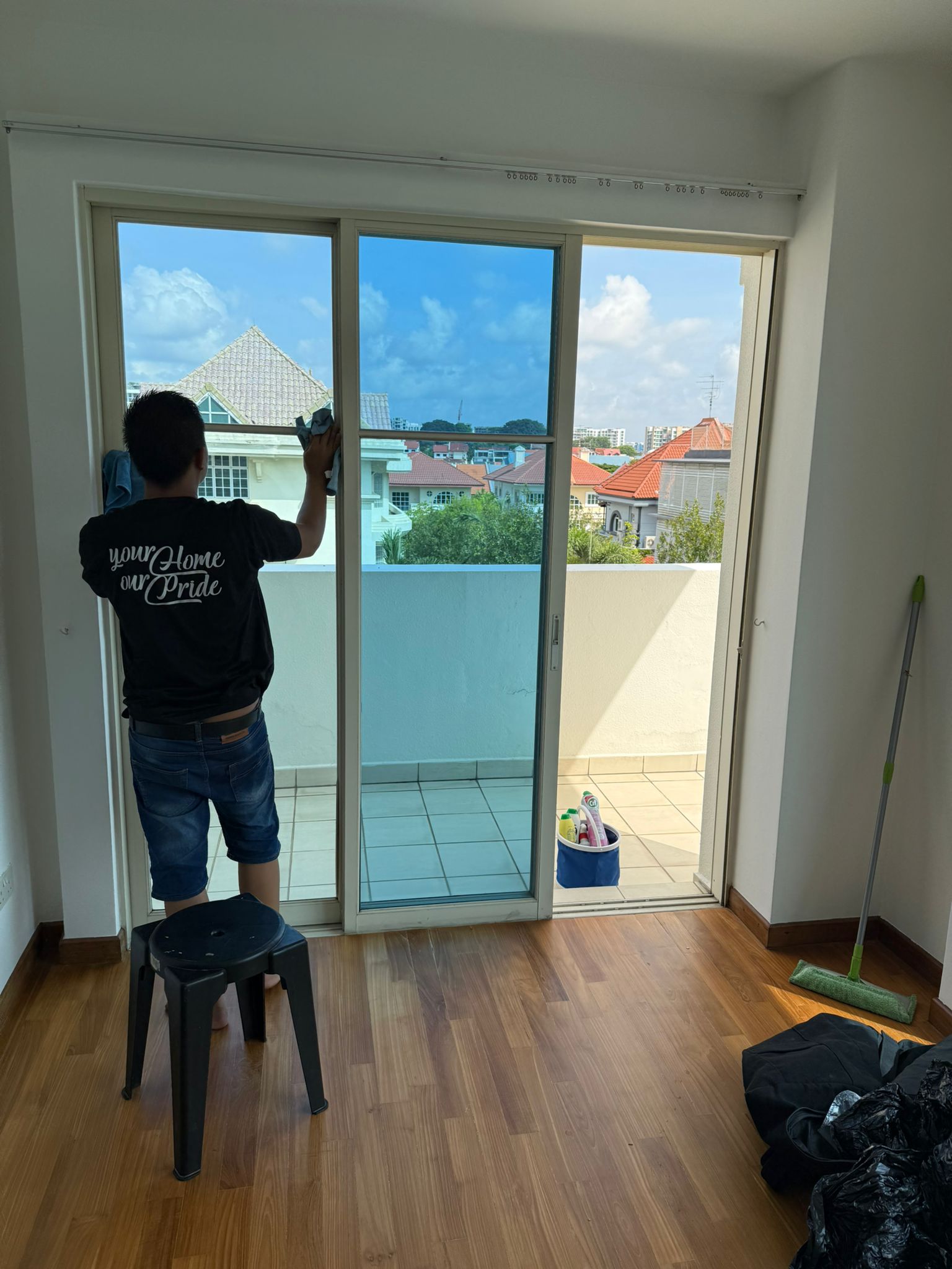 Professional cleaner on a ladder cleaning high windows with safety equipment
