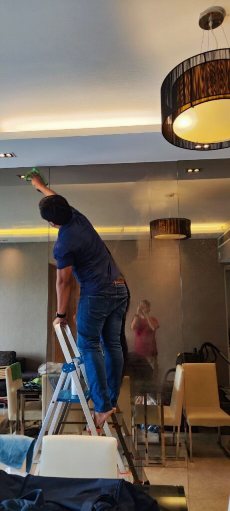 Team of professional cleaners performing deep cleaning on mirrors and surfaces